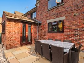 An outdoor dining area with a table and chairs at 1 Stanway Road