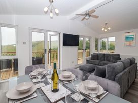 A living room with a dining table and a couch at Lodge 19 in Torpoint