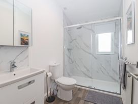 A bathroom with a sink, shower, and towel rail at Lodge 19 in Torpoint