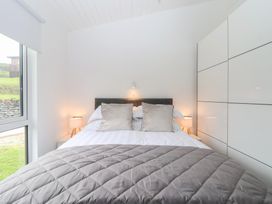 A bedroom with a bed and lamps at Lodge 19 in Torpoint