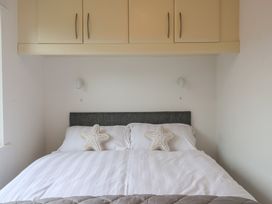 A bedroom with a bed and wall cabinet at Lodge 19 in Torpoint