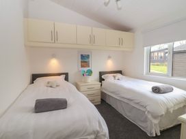 A bedroom with twin beds and a window at Lodge 19 in Torpoint