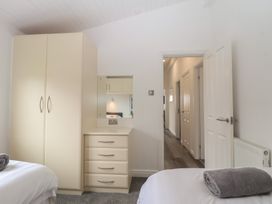 A bedroom with a wardrobe and chest of drawers at Lodge 19 in Torpoint