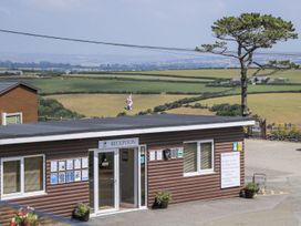 A reception building with a view of fields and a tree at Lodge 19 Torpoint