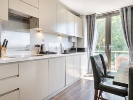 A kitchen with cabinets and a table at Cotswolds Apartment, sleeps 4 in Chipping Norton