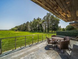 An outdoor patio with a table and chairs overlooking a grassy area at Cotswolds Apartment, sleeps 4, Chipping Norton