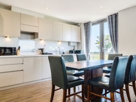 A kitchen with cabinets and a dining table at Cotswolds Apartments 2B/S4 in Chipping Norton
