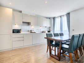 A kitchen with cabinets, a table, and chairs at Cotswolds Apartments 4B/S8 in Chipping Norton