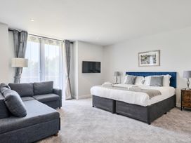 A bedroom with a king size bed and a sofa at Cotswolds Apartments 4B/S8 in Chipping Norton