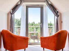 A sitting room with chairs overlooking a balcony at Cotswolds Apartments 4B/S8 in Chipping Norton