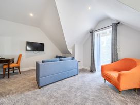 A living room with a sofa and television at Cotswolds Apartments 4B/S8 in Chipping Norton