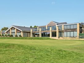 A building with large windows and balconies on a golf course at Cotswolds Apartments 4B/S8 in Chipping Norton