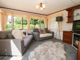 A snug with sofas and a television at Buzzards Retreat in Wrexham