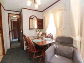 A dining room with a table and chairs at Buzzards Retreat in Wrexham