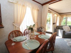 A dining room with a table set for four at Buzzards Retreat in Wrexham
