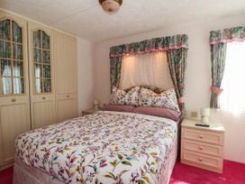 A bedroom with a bed and wardrobe at Buzzards Retreat in Wrexham