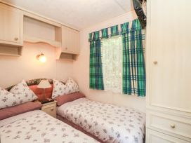 A bedroom with two beds and a wardrobe at Buzzards Retreat in Wrexham