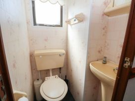 A bathroom with a toilet and sink at Buzzards Retreat in Wrexham