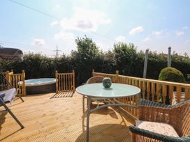 A garden with a hot tub and seating area at Buzzards Retreat in Wrexham