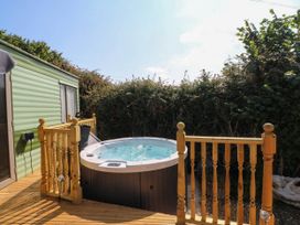 An outdoor area with a hot tub and wooden decking at Buzzards Retreat in Wrexham