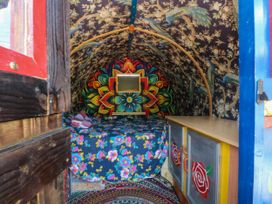 A bedroom with colorful decor and a floral blanket at Buzzards Retreat in Wrexham