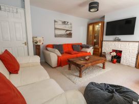 A living room with a sofa, coffee table, and television at Driftmark in Weymouth