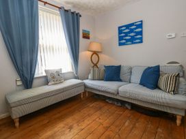 A living room with a sofa and lamp at Driftmark in Weymouth