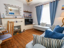 A living room with a television and sofa at Driftmark in Weymouth