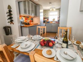 A dining table set with plates and fruit in the kitchen at Driftmark in Weymouth