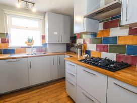 A kitchen with cabinets and a stove at Driftmark in Weymouth