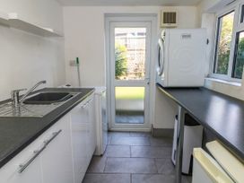 A utility room with a sink and washing machine at Driftmark in Weymouth