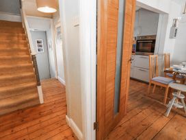 A hallway with a staircase and door leading to a kitchen at Driftmark in Weymouth