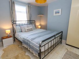 A bedroom with a bed and bedside table at Driftmark in Weymouth