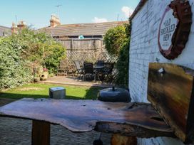 A garden with seating area and wooden table at Driftmark in Weymouth