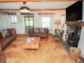 A living room with a sofa, coffee table, and fireplace at Haws Bank Cottage in Coniston