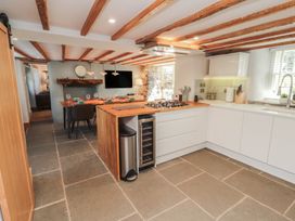 A kitchen with an island and dining area at Haws Bank Cottage in Coniston
