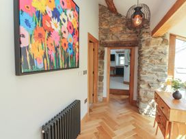 A hallway with a painting and wooden table at Haws Bank Cottage Coniston