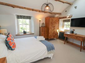 A bedroom with a bed and wardrobe at Haws Bank Cottage in Coniston