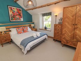 A bedroom with a bed and bedside tables at Haws Bank Cottage in Coniston