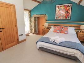 A bedroom with a bed and artwork at Haws Bank Cottage in Coniston