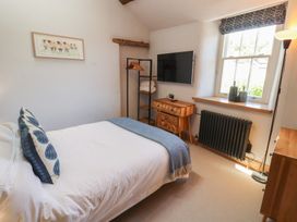 A bedroom with a bed and television at Haws Bank Cottage in Coniston