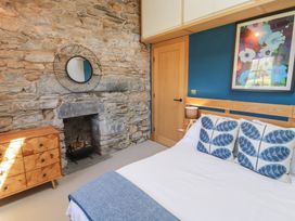 A bedroom with a bed and fireplace at Haws Bank Cottage in Coniston