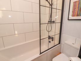 A bathroom with a bathtub and shower at Haws Bank Cottage in Coniston