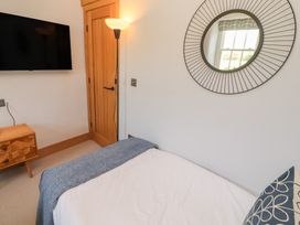 A bedroom with a bed and television at Haws Bank Cottage in Coniston