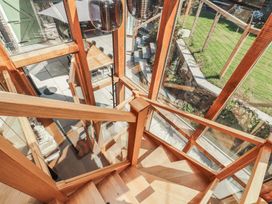 A staircase with glass railing overlooking a garden at Haws Bank Cottage, Coniston