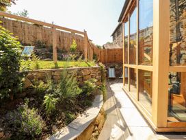 A garden with plants and a glass structure at Haws Bank Cottage in Coniston