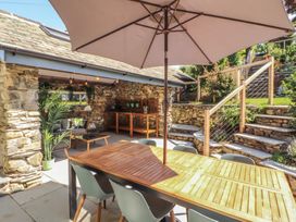 An outdoor dining area with a table and umbrella at Haws Bank Cottage in Coniston