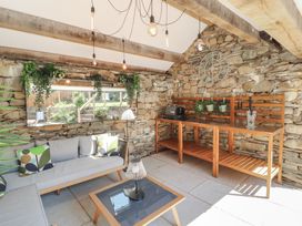 A conservatory with a sofa and table at Haws Bank Cottage in Coniston