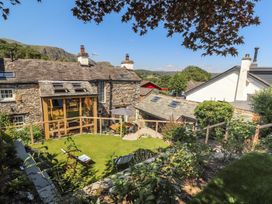 A garden with lawn and wooden structures at Haws Bank Cottage in Coniston