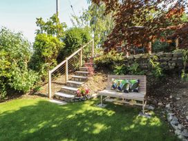 A garden with stairs and a bench at Haws Bank Cottage in Coniston
